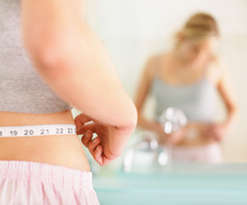 Image of a woman measuring her waist size