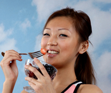 Image of a woman eating fruits with a fork