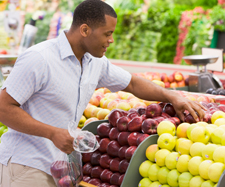 Image of a man selecting fresh fruits from a shop