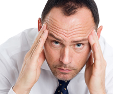 Image of a male professional holding his head